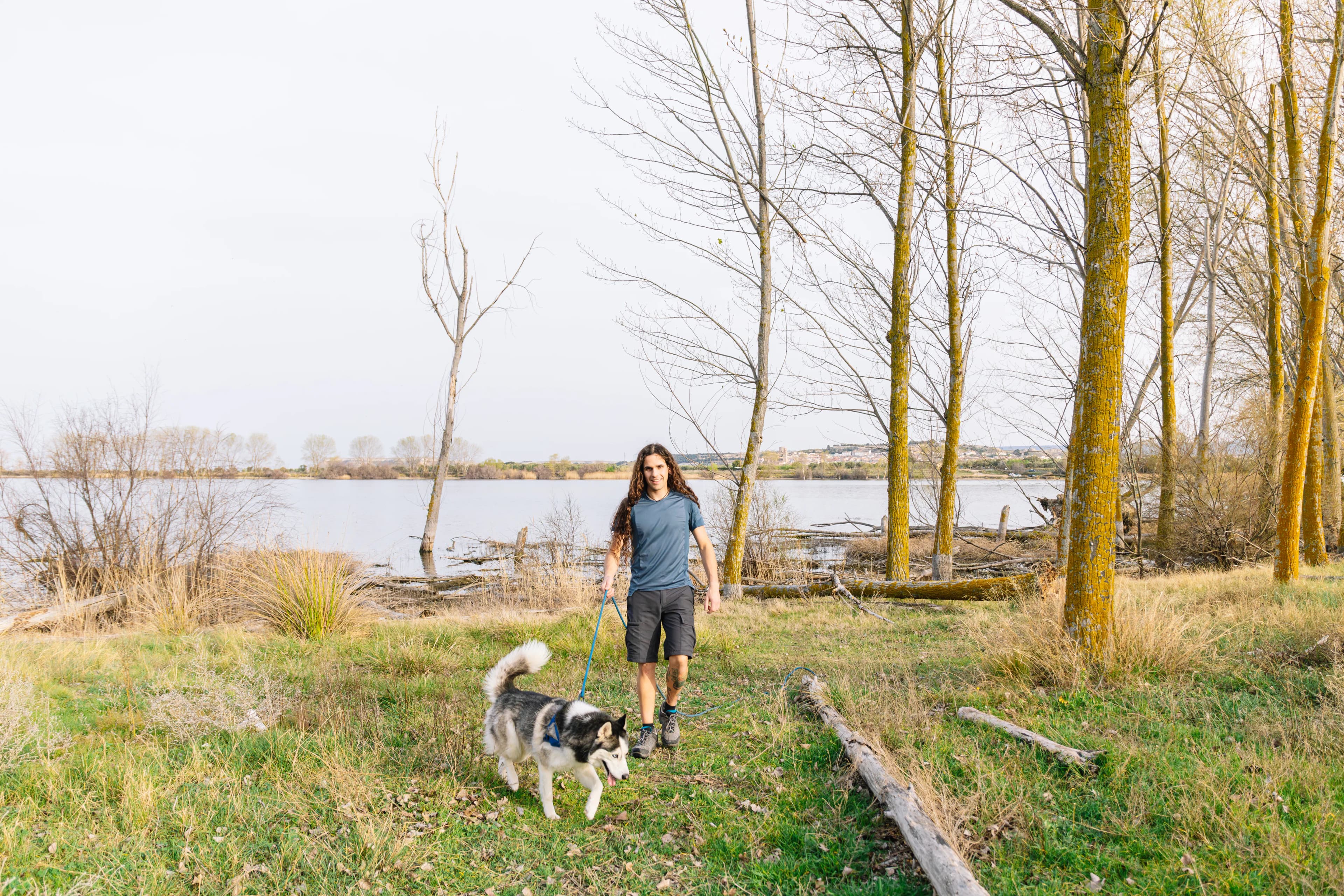 Person walking with a husky beside the waterfront in Richmond, British Columbia