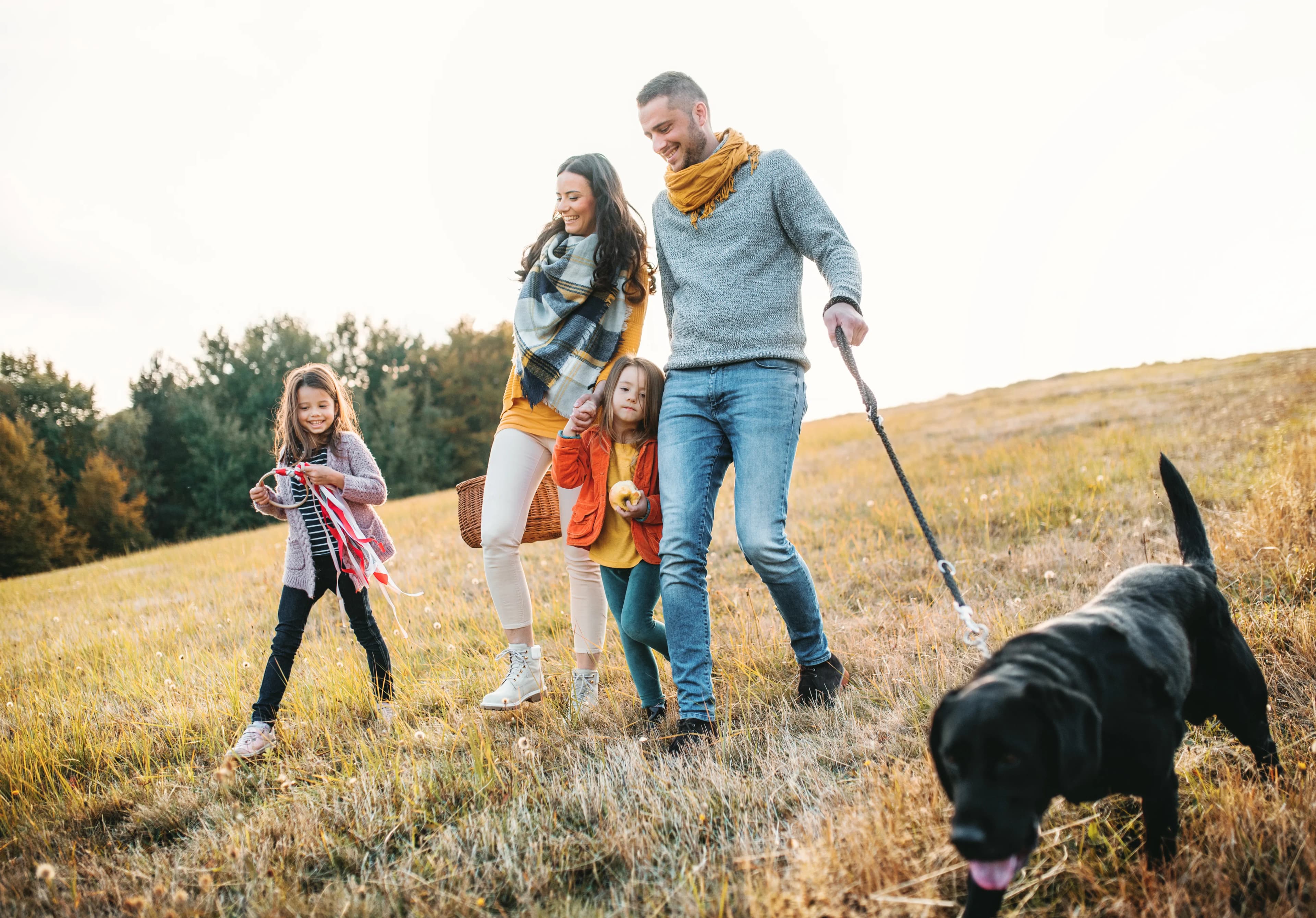 A family walking together with their dog at golden hour