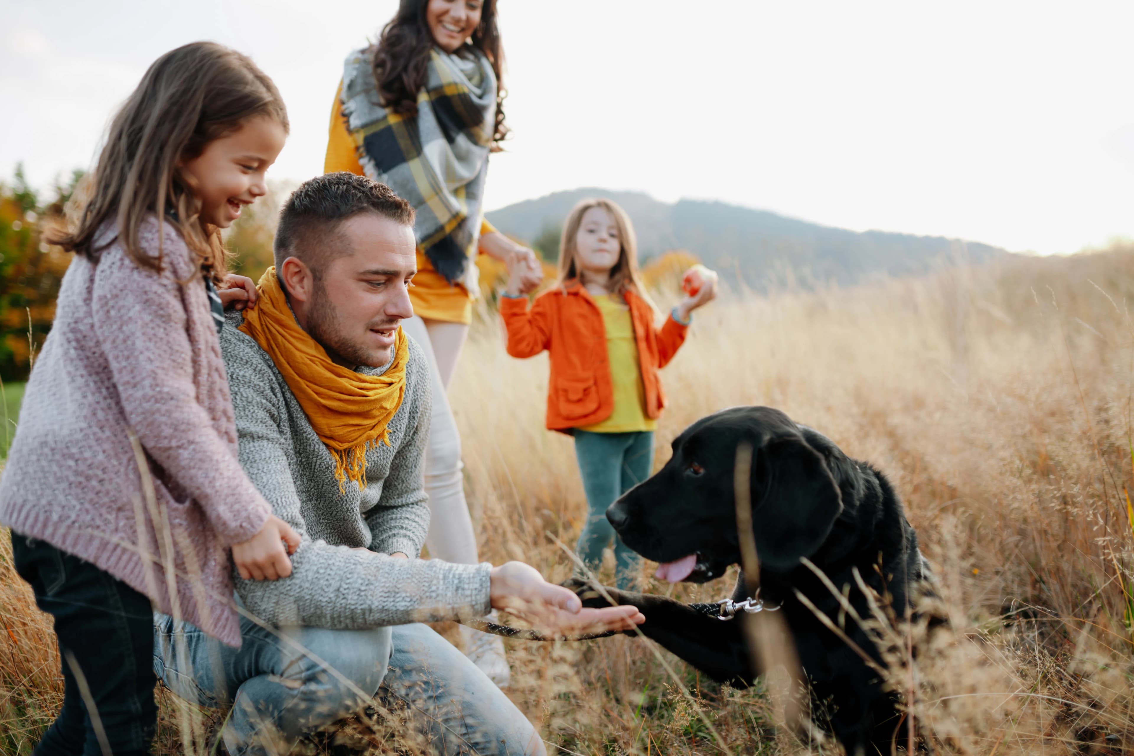 A family sharing a joyful moment with their dog by PetLens