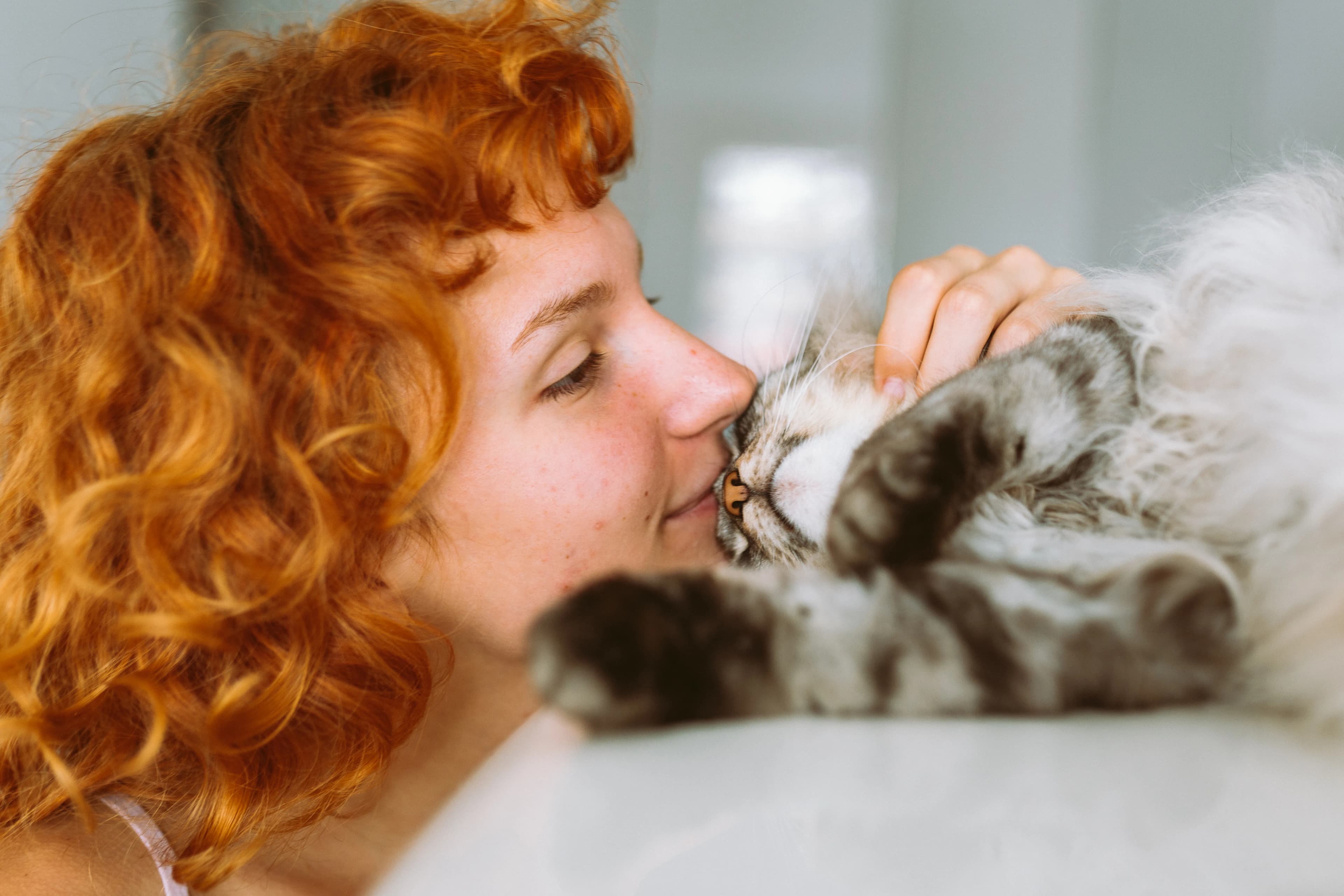 A woman sharing a close affectionate moment with her cat