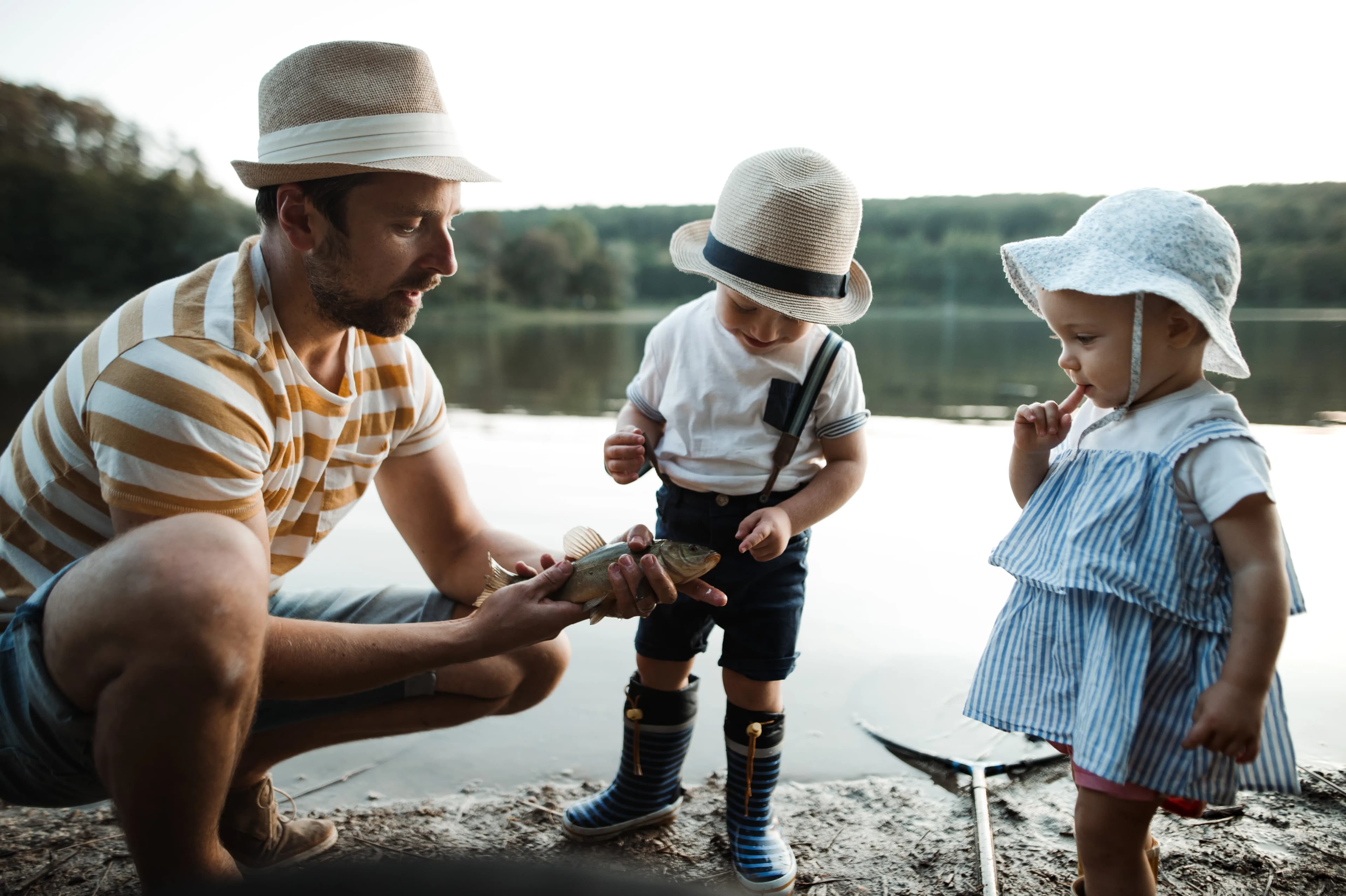 Children enjoying an outdoor fishing adventure with their father