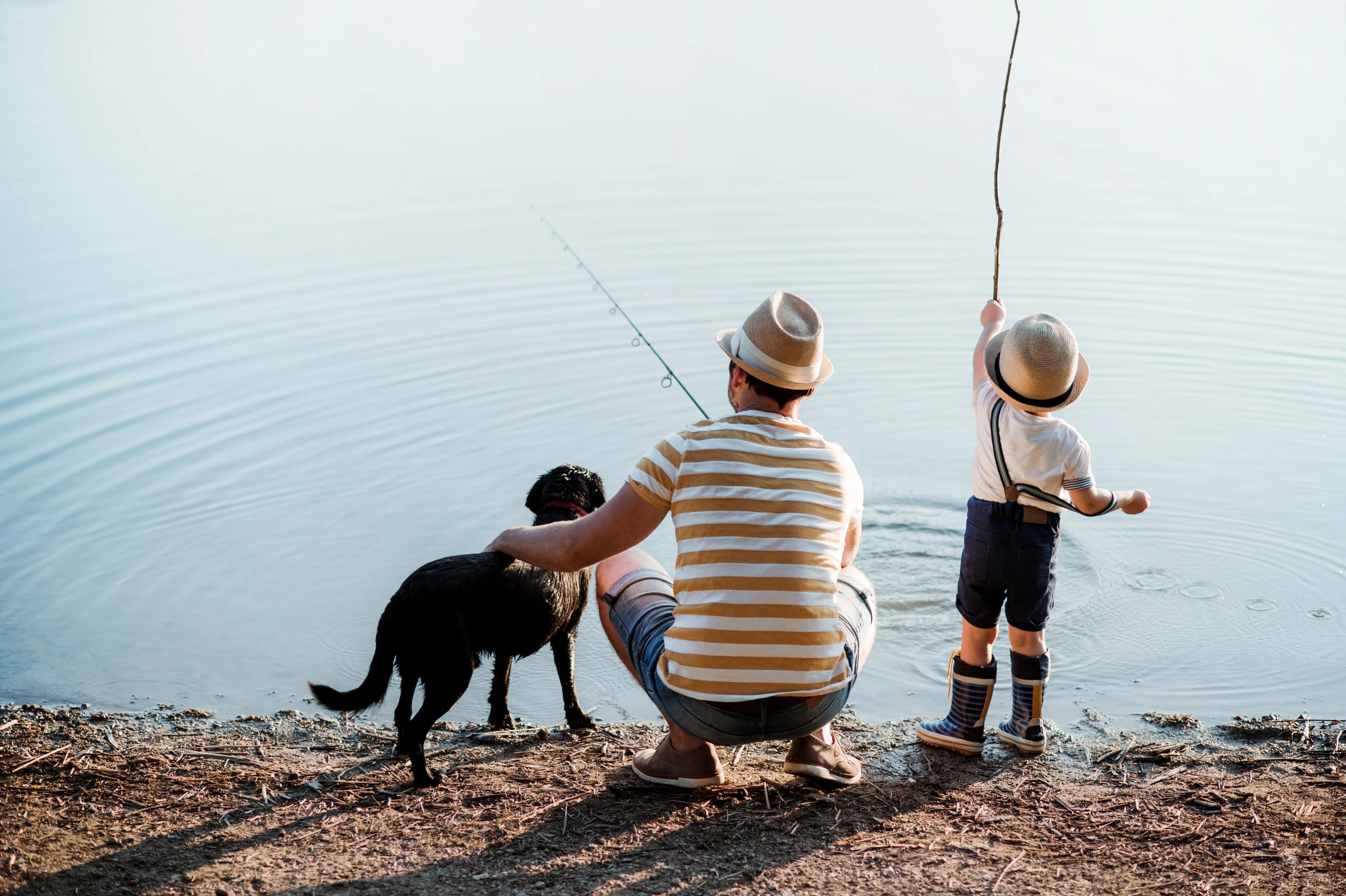 A father, boy, and their dog arriving at a lake for a day outdoors