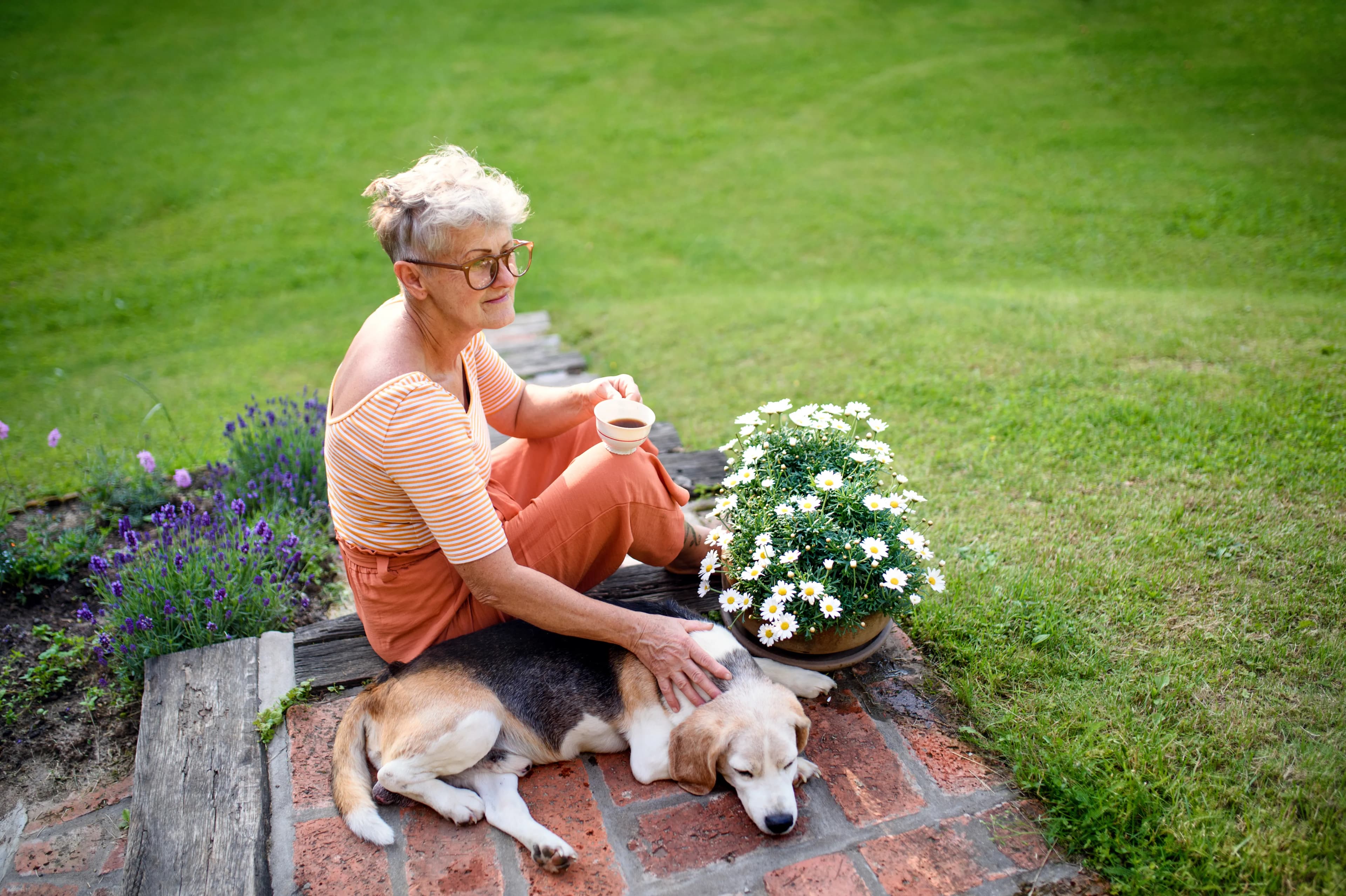 A woman relaxing with her dog in the garden