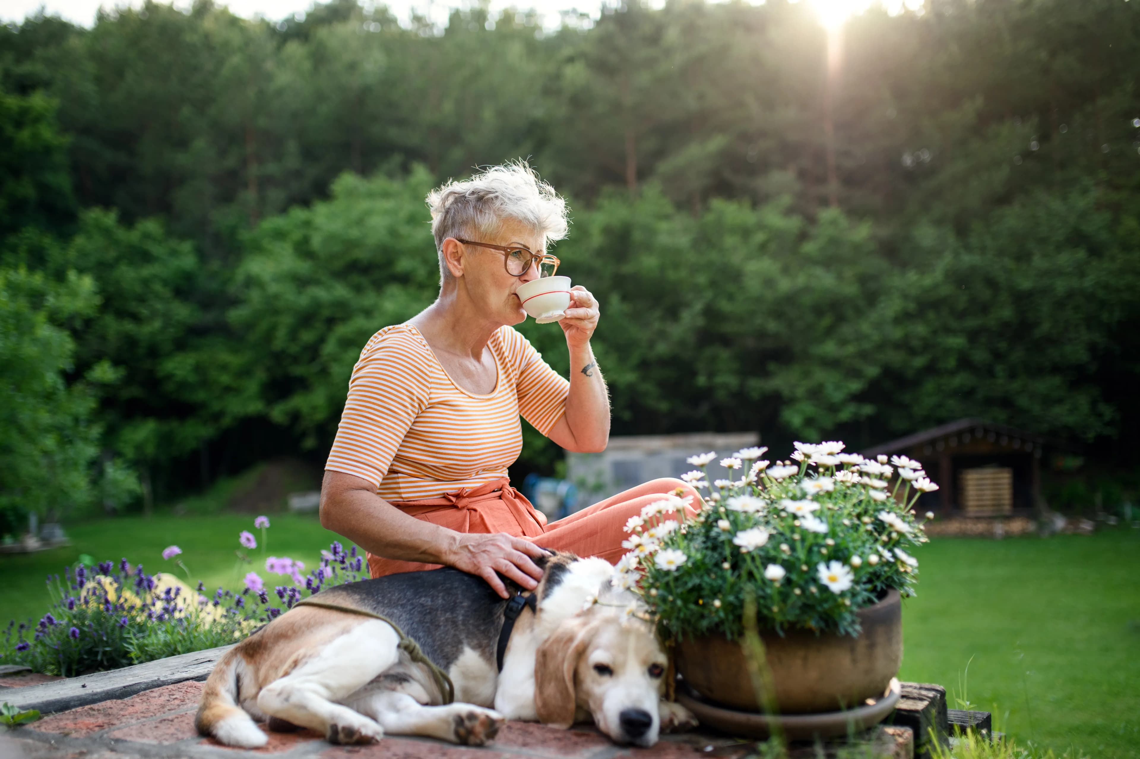 A woman sharing a quiet moment with her dog in her garden