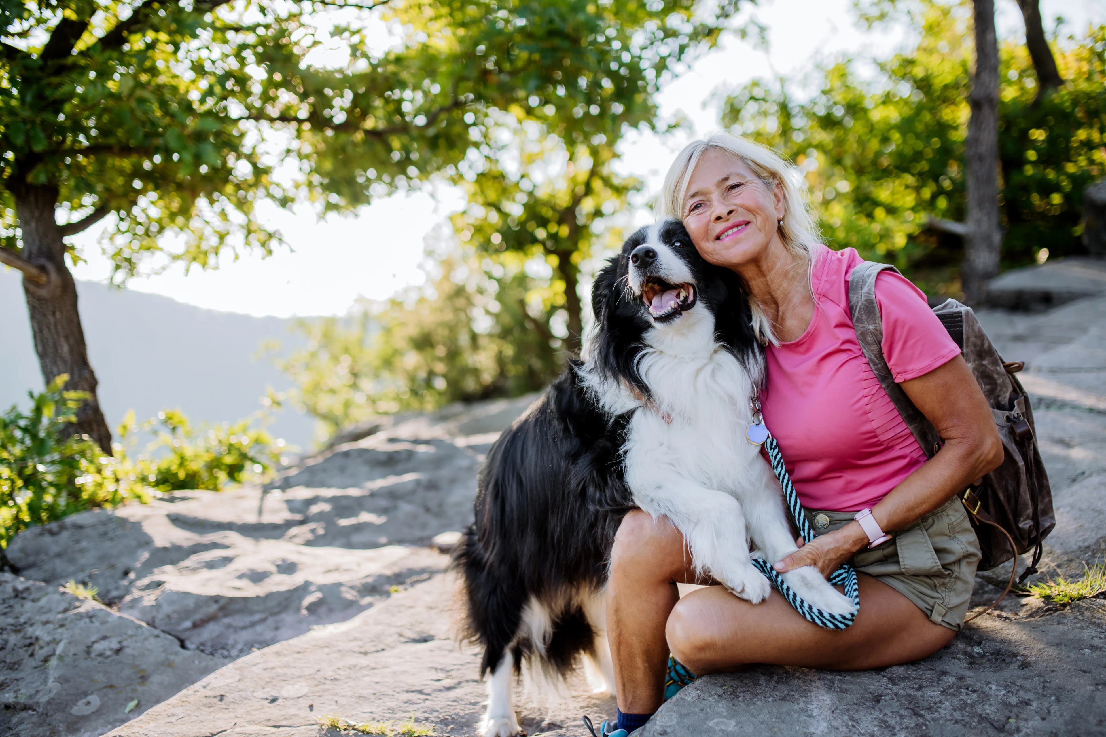 Woman sitting with her dog on a rocky outdoor trail in North Vancouver