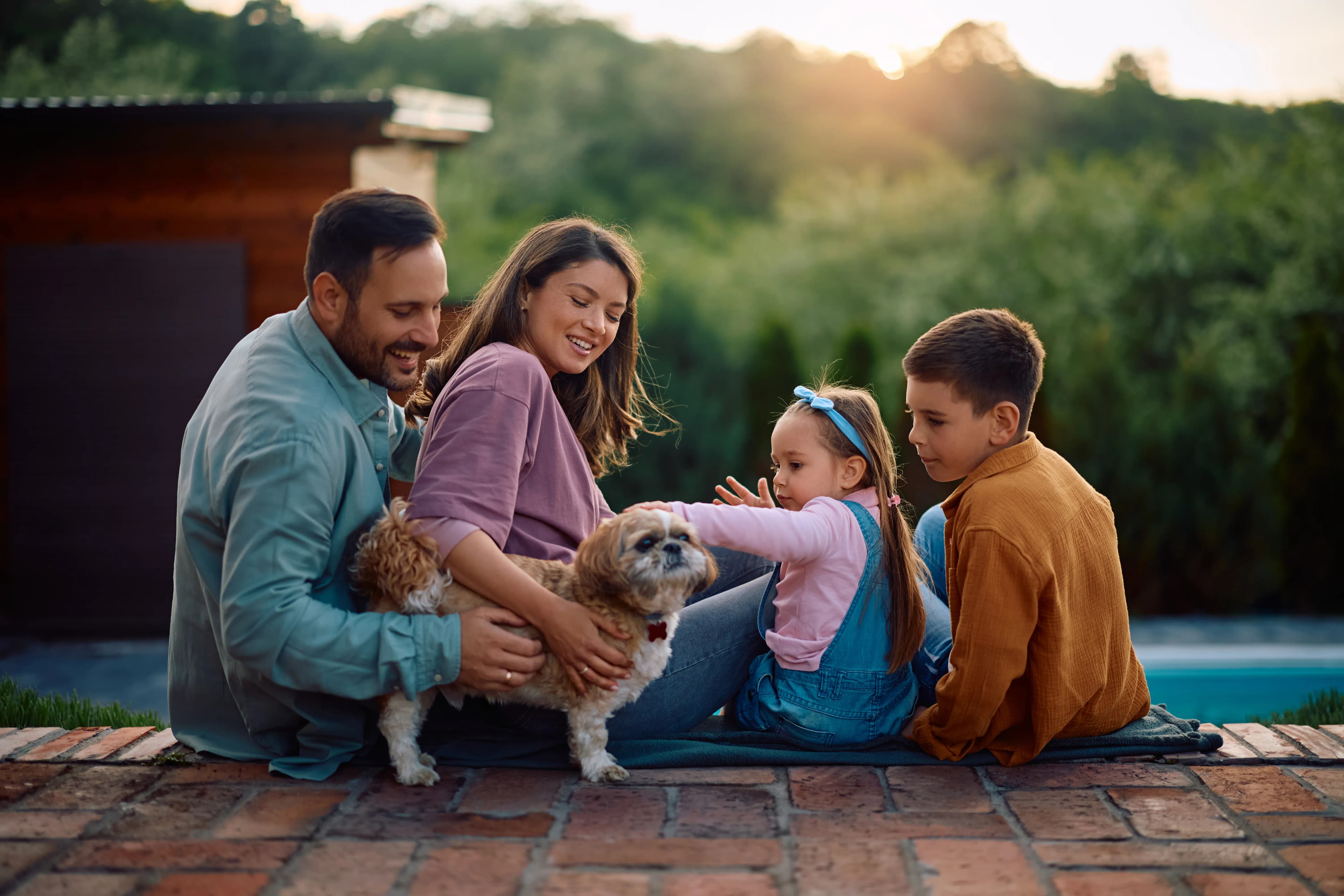 A family sharing a relaxed outdoor moment with their dog